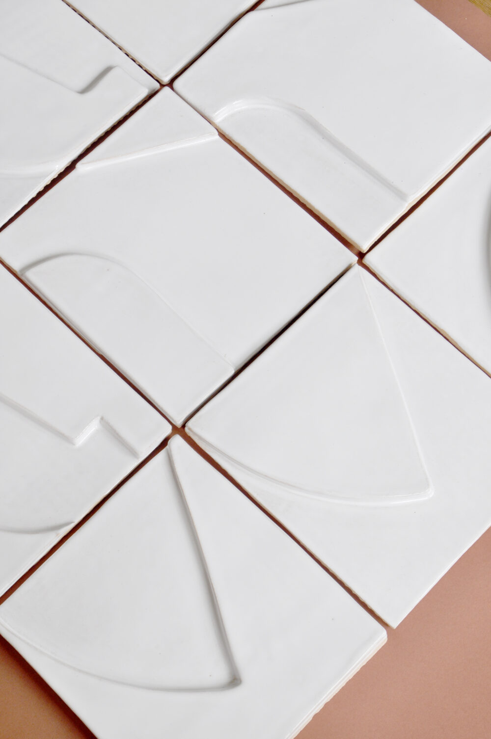 White smooth handmade relief ceramic tiles on terracotta background